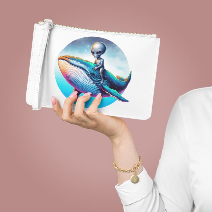 Clutch bag featuring an illustration of an alien riding a whale against a colorful background.